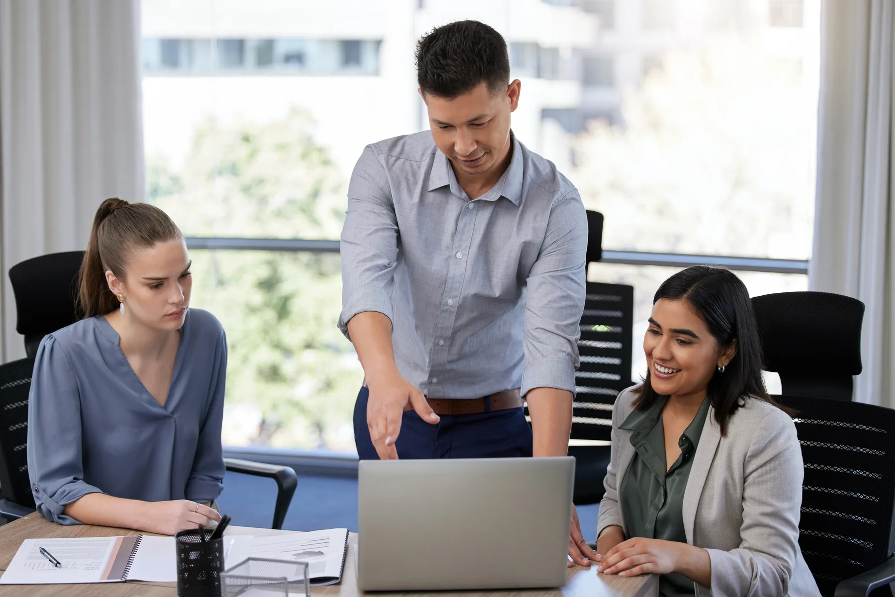 A formally dressed bookkeeping advisor reviewing business information with small-business clients
